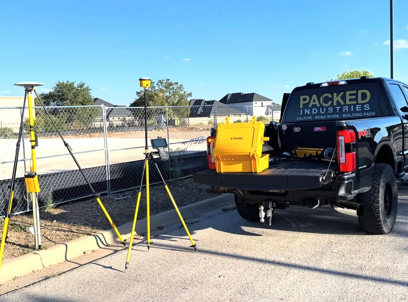 Packed Industries pickup with surveying equipment and yellow equipment cases
